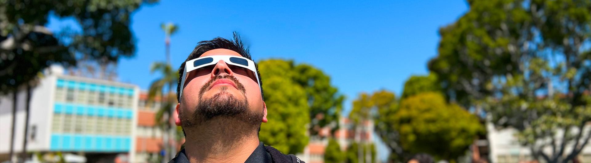  staffer looks through eclipse glasses