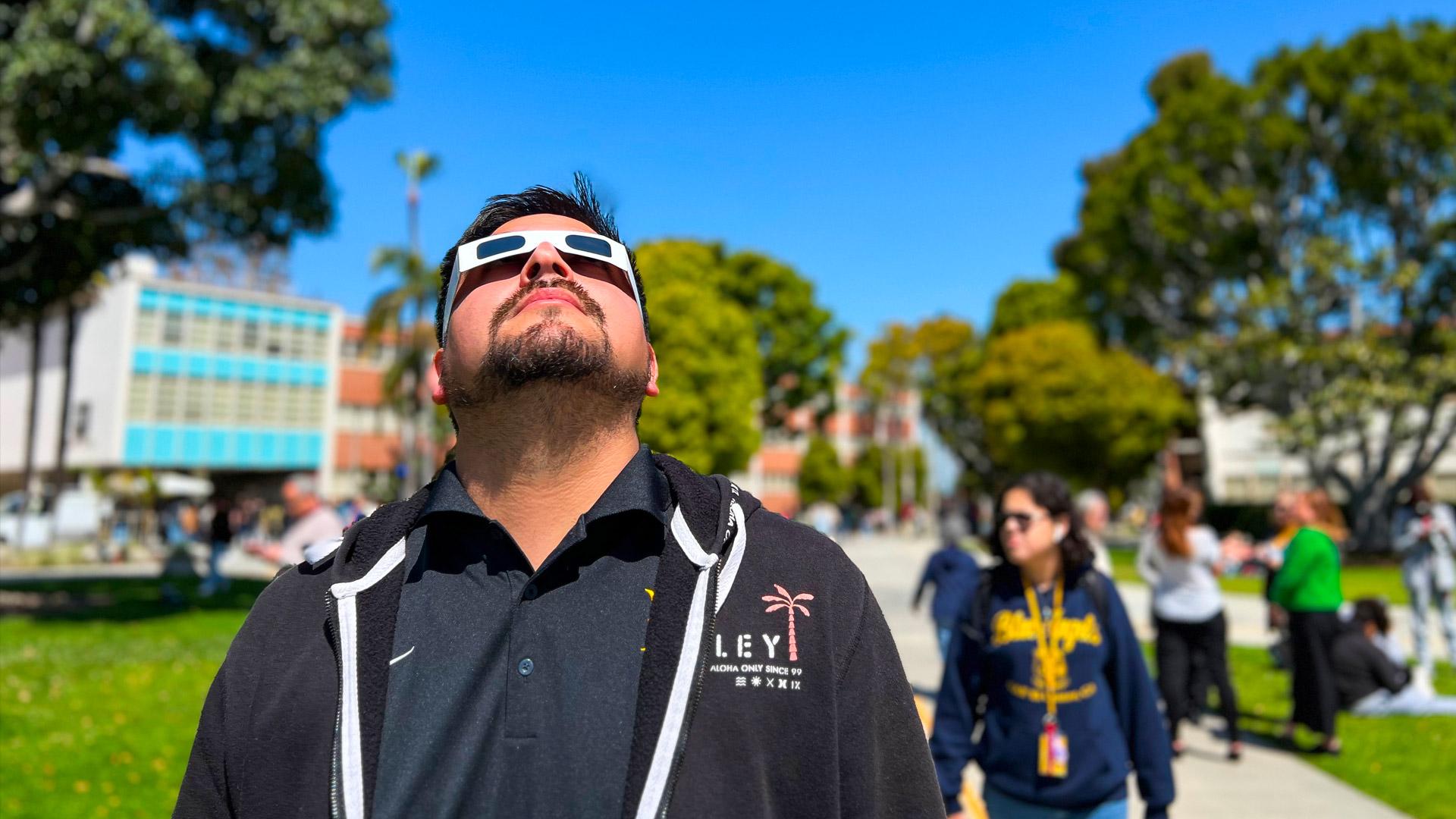 Man gazes at sky on  campus during the partial solar eclipse