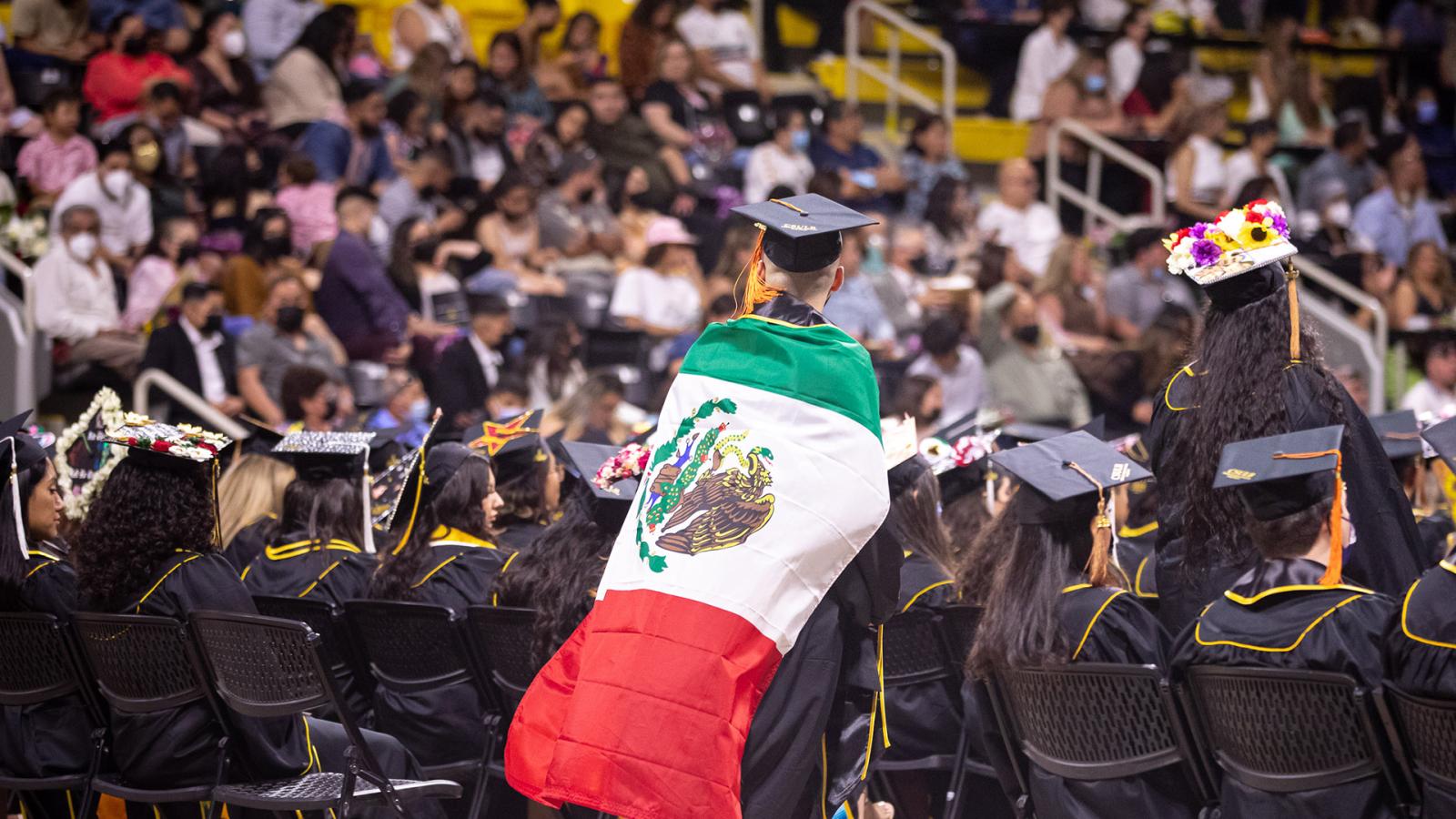 Latino student with flag wrapped around him